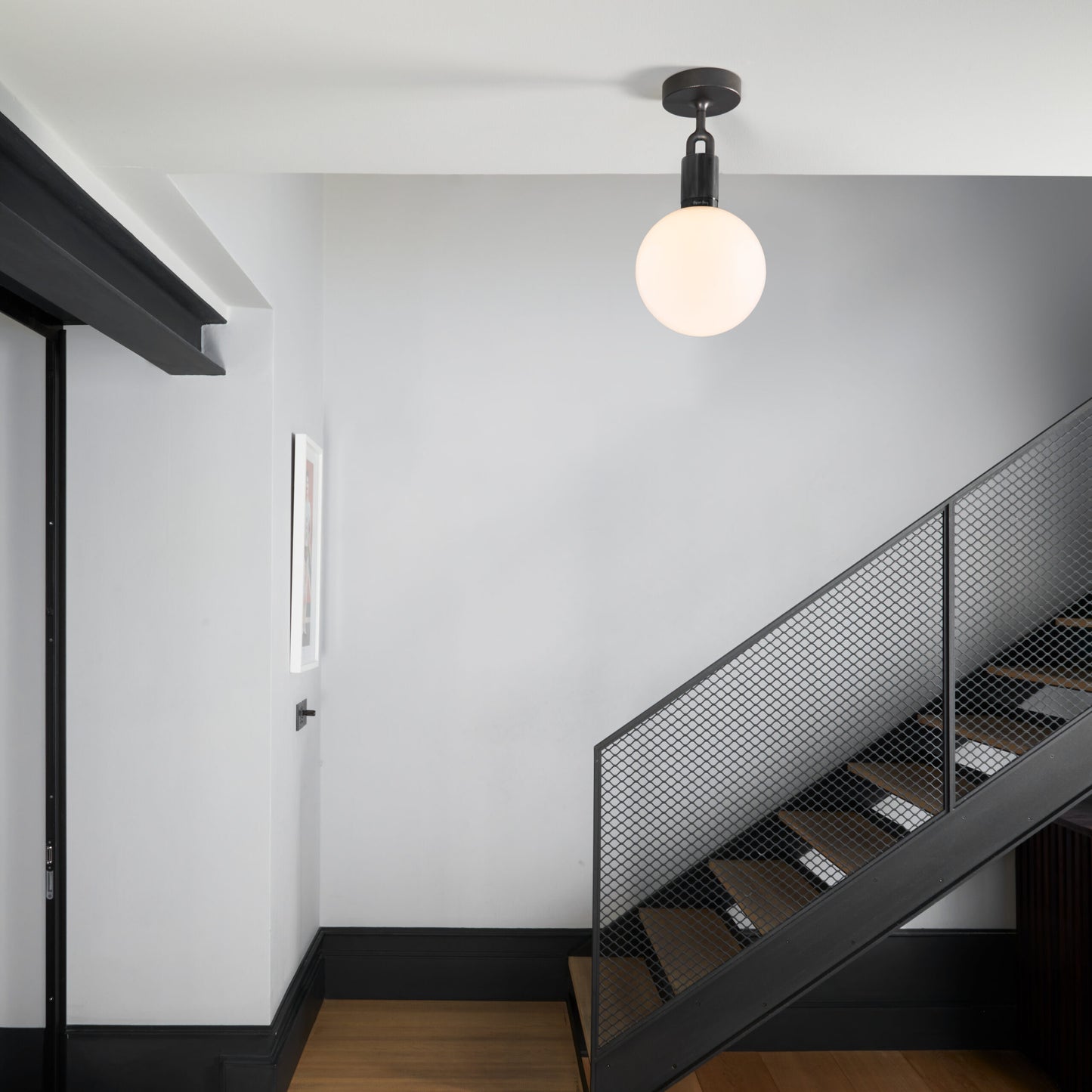 Forked Ceiling Light / Globe / Opal / Medium Gun metal, on ceiling in hallway setting.