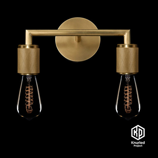 Brass double wall light with two filament bulbs on black background