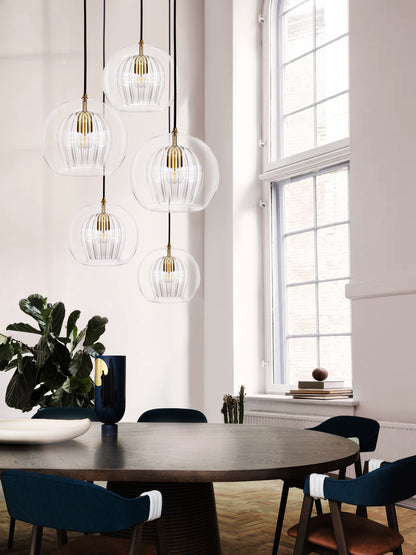 Pleated Crystal 5 Pendant Cluster Light clear, hanging from ceiling above table in setting.