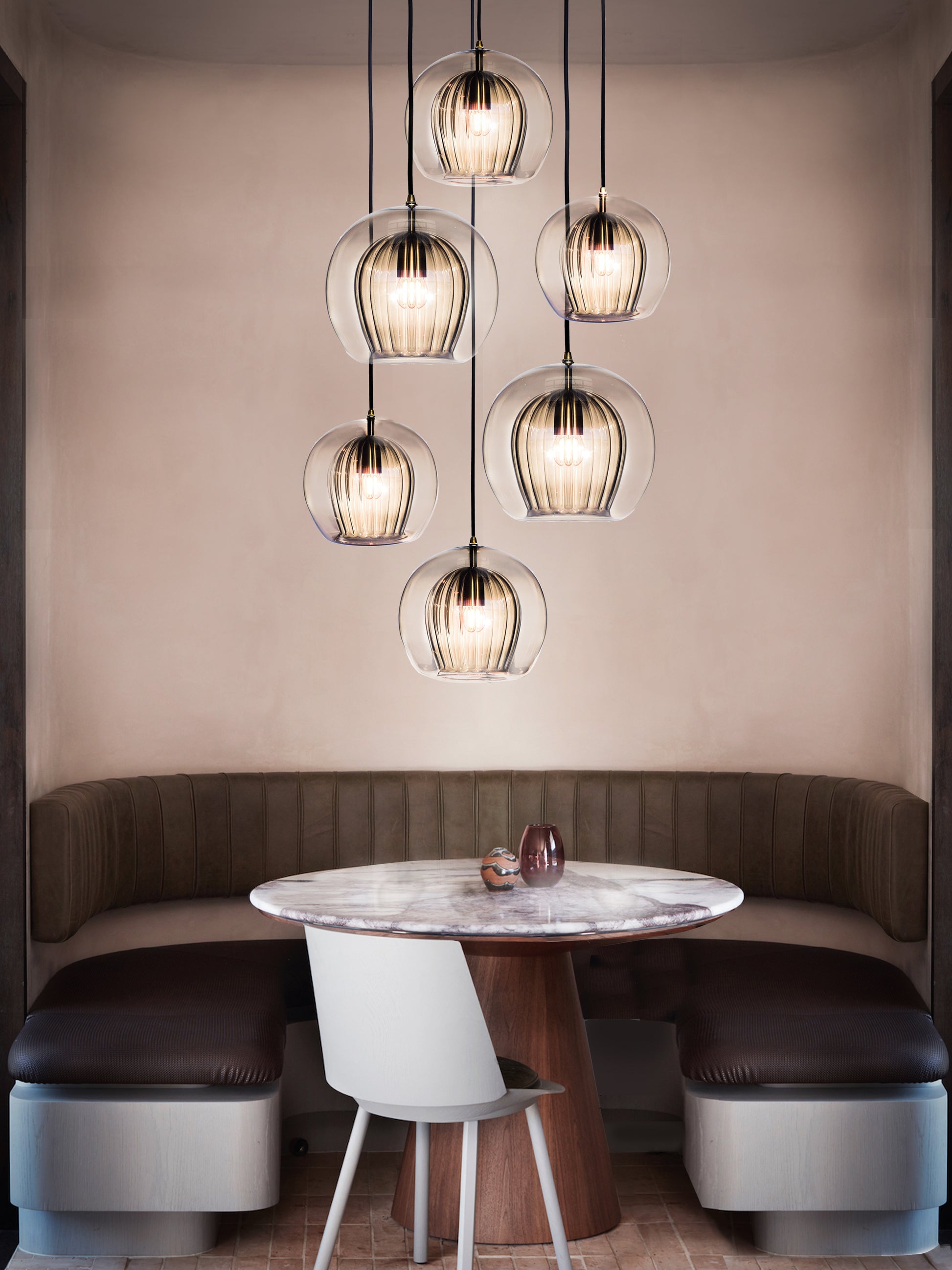 Pleated Crystal 5 Pendant Cluster Light smoked, hanging from ceiling above table in setting.