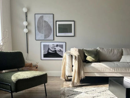 Charcoal grey Bar Opal Ball Wall Light, in living room setting.